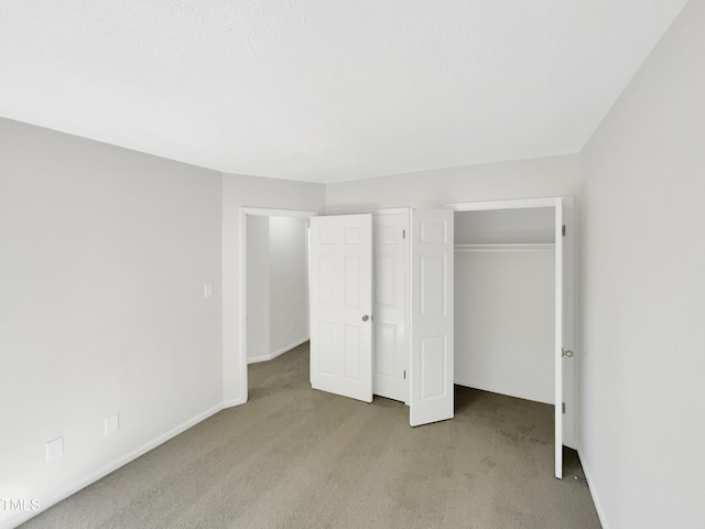 unfurnished bedroom with a closet and light colored carpet