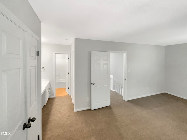 unfurnished bedroom featuring connected bathroom and carpet floors