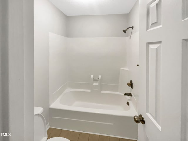 bathroom featuring shower / bathing tub combination and toilet