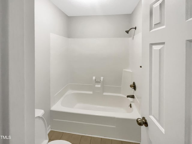 bathroom featuring shower / washtub combination and toilet