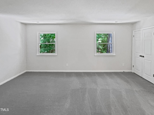 carpeted spare room featuring baseboards