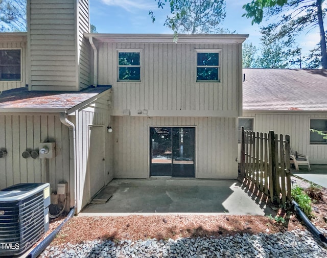 rear view of house featuring central air condition unit, a patio, and a chimney