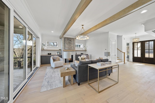 living area with french doors, beamed ceiling, plenty of natural light, and crown molding