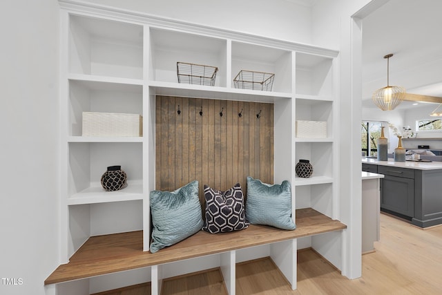 mudroom featuring built in features and light wood-style floors