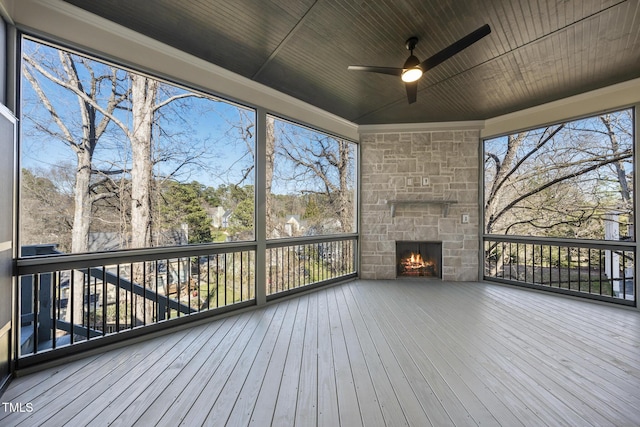 deck featuring a stone fireplace and a ceiling fan