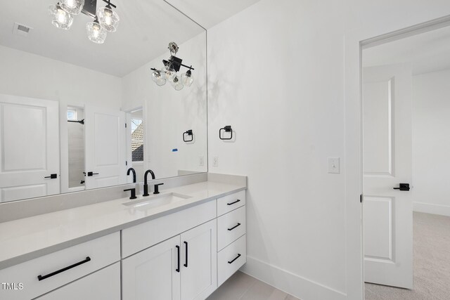 bathroom featuring visible vents, baseboards, and vanity