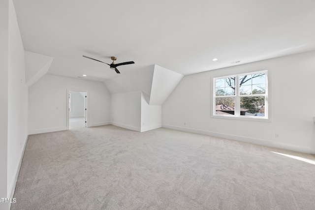 additional living space with vaulted ceiling, ceiling fan, light carpet, and baseboards