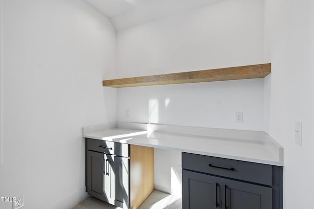 kitchen with gray cabinets, light countertops, light carpet, and open shelves