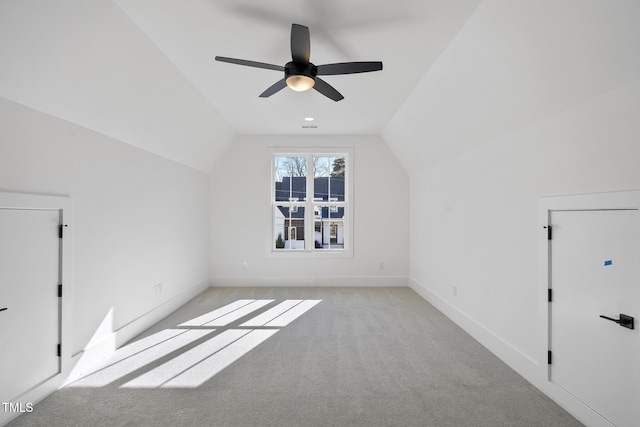 additional living space with light carpet, ceiling fan, vaulted ceiling, and baseboards