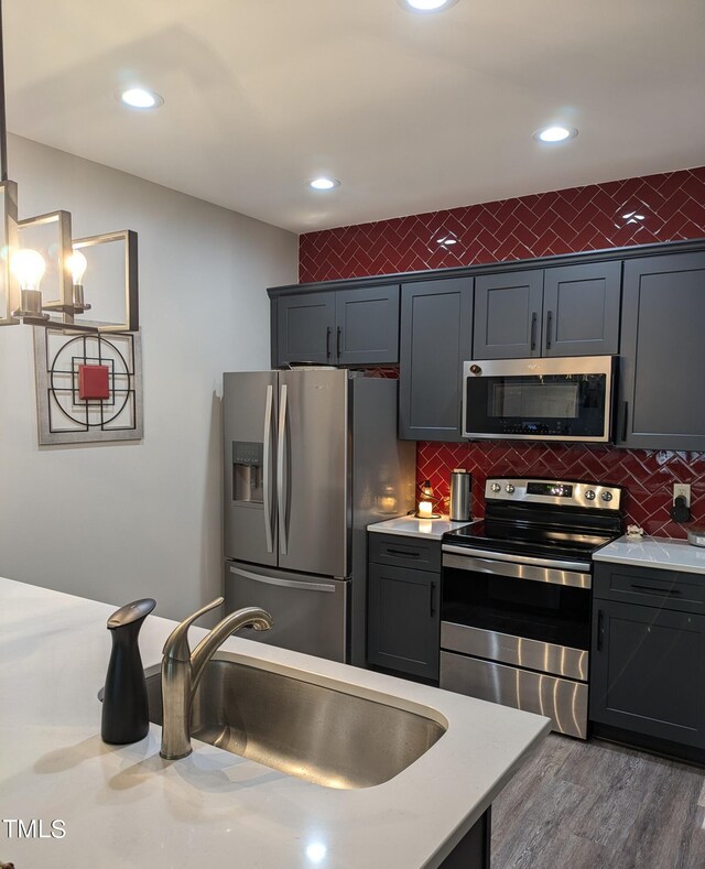 kitchen featuring sink, decorative backsplash, appliances with stainless steel finishes, and dark wood-type flooring