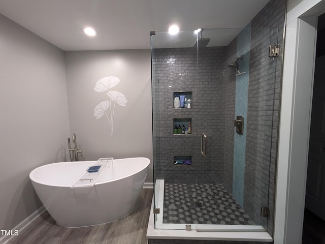 bathroom featuring plus walk in shower and hardwood / wood-style floors