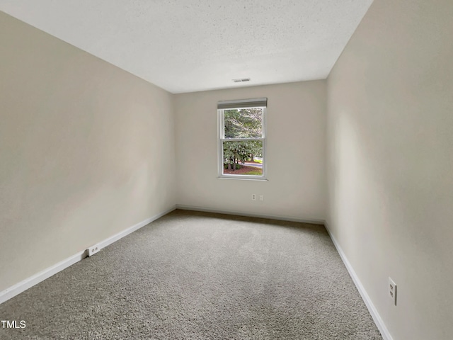 carpeted empty room featuring a textured ceiling