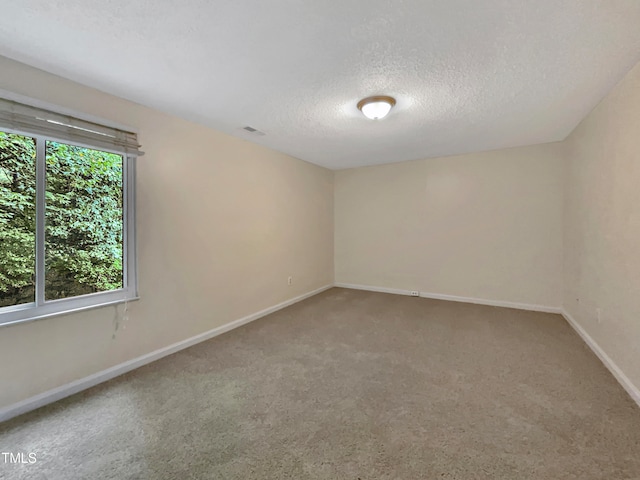 carpeted empty room with a textured ceiling