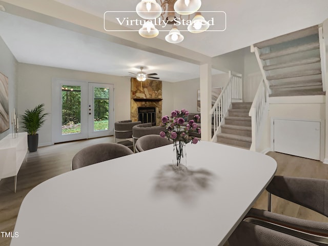 dining room featuring wood-type flooring, a fireplace, and ceiling fan