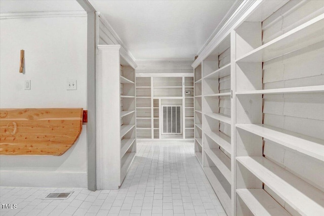 walk in closet with light tile patterned floors