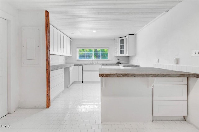 kitchen featuring white cabinetry, light tile patterned floors, sink, and electric panel