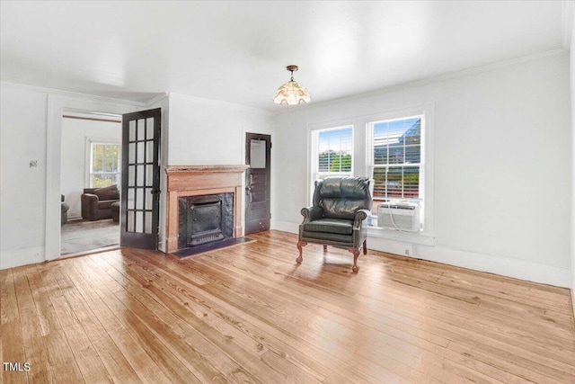 unfurnished living room featuring crown molding, a premium fireplace, wood-type flooring, and cooling unit