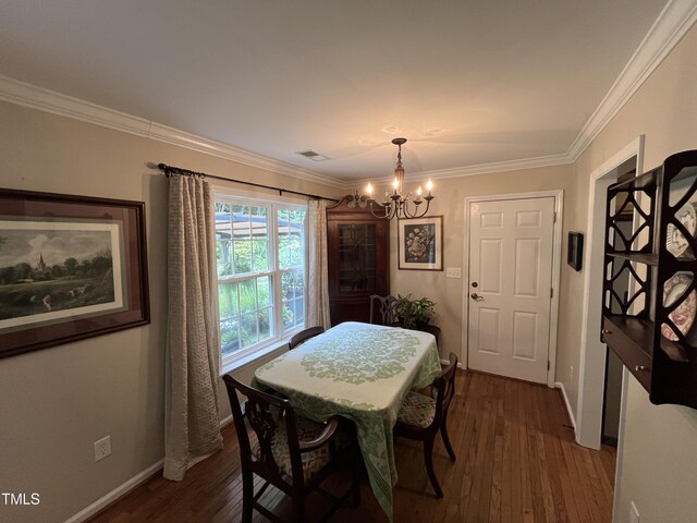 dining space with crown molding, an inviting chandelier, and dark hardwood / wood-style floors