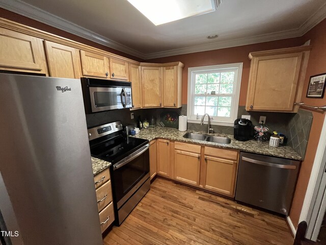 kitchen featuring backsplash, stainless steel appliances, light hardwood / wood-style floors, sink, and crown molding