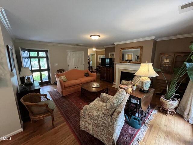 living room featuring crown molding and wood-type flooring