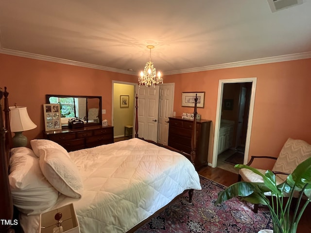 bedroom with a notable chandelier, ornamental molding, wood-type flooring, and ensuite bathroom