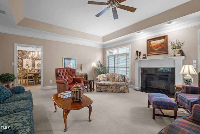 carpeted living area featuring ornamental molding, a raised ceiling, and a high end fireplace