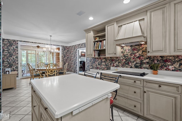 kitchen with light countertops, black electric stovetop, decorative light fixtures, and wallpapered walls