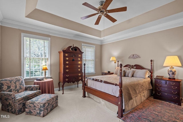 bedroom featuring ornamental molding, a raised ceiling, and multiple windows