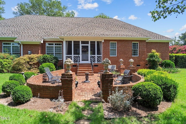 back of property featuring brick siding, a patio, roof with shingles, an outdoor fire pit, and crawl space