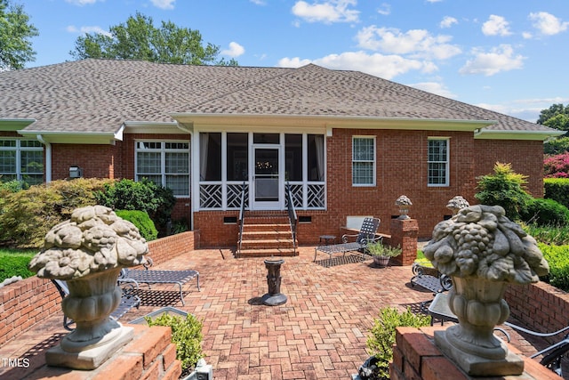 rear view of house featuring crawl space, entry steps, roof with shingles, and a patio