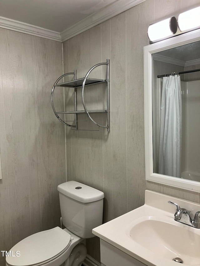 bathroom featuring toilet, crown molding, vanity, curtained shower, and wood walls