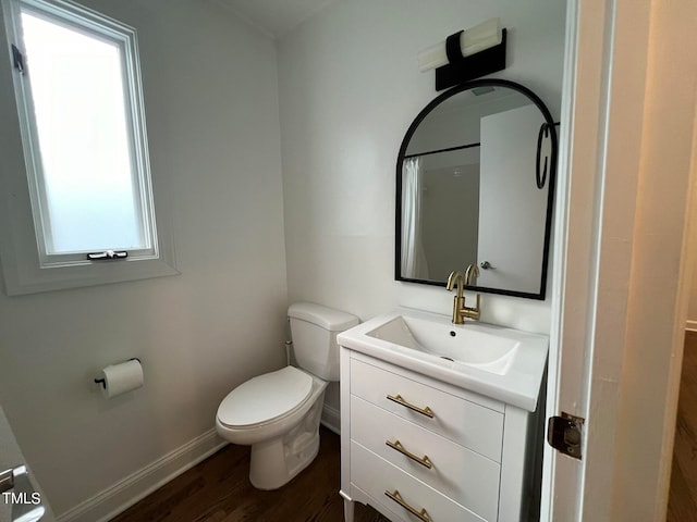 bathroom with a healthy amount of sunlight, toilet, hardwood / wood-style flooring, and vanity