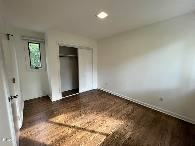 unfurnished bedroom featuring dark wood-type flooring and a closet