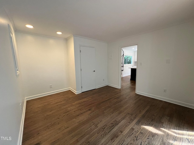 spare room featuring dark hardwood / wood-style flooring and crown molding