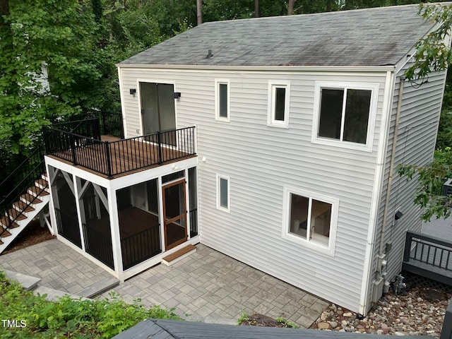 back of property with a wooden deck and a patio area