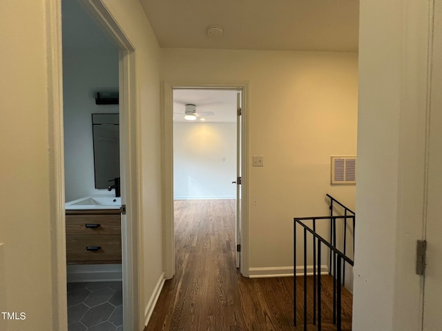 hallway with dark wood-type flooring and sink