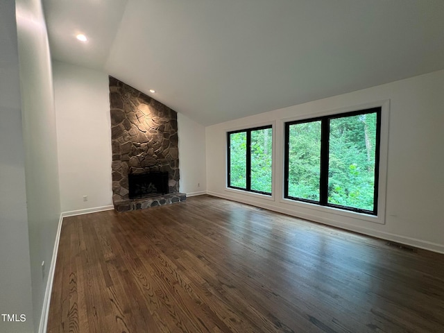 unfurnished living room with vaulted ceiling, dark hardwood / wood-style flooring, and a fireplace