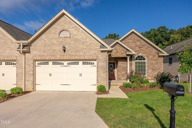 view of front of house with an attached garage, brick siding, concrete driveway, and a front yard