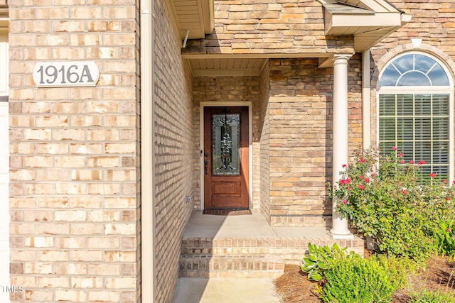 view of exterior entry with stone siding and brick siding