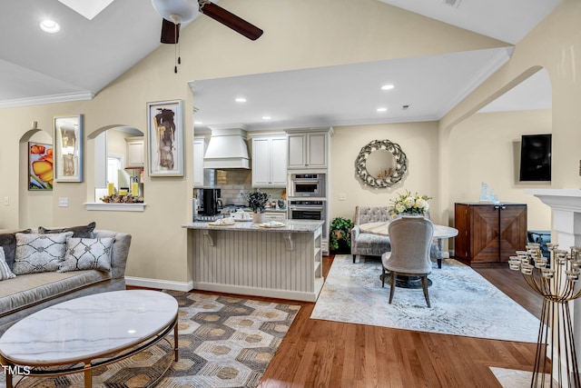 living room featuring crown molding, recessed lighting, vaulted ceiling, ceiling fan, and wood finished floors