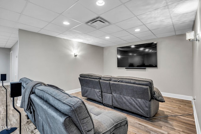 home theater room featuring recessed lighting, visible vents, wood finished floors, a drop ceiling, and baseboards