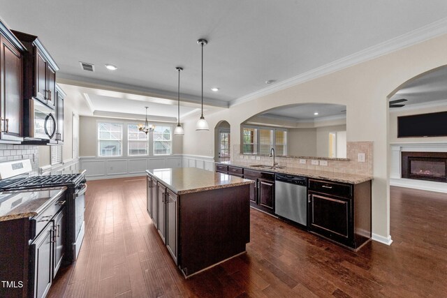 kitchen featuring backsplash, appliances with stainless steel finishes, and dark wood-type flooring