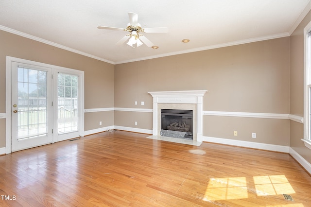 unfurnished living room with ceiling fan, ornamental molding, light hardwood / wood-style floors, and a premium fireplace