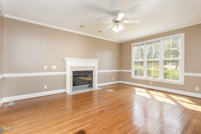 unfurnished living room featuring a fireplace, ornamental molding, light hardwood / wood-style flooring, and ceiling fan