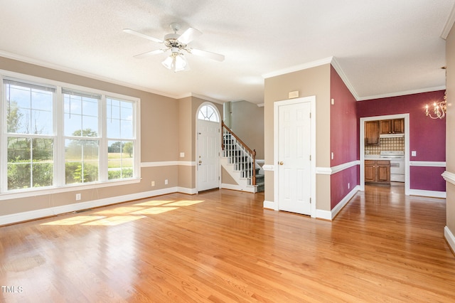 spare room featuring crown molding, light hardwood / wood-style flooring, ceiling fan with notable chandelier, and a textured ceiling