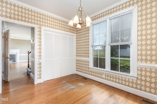 interior space featuring crown molding, a notable chandelier, a closet, and light wood-type flooring