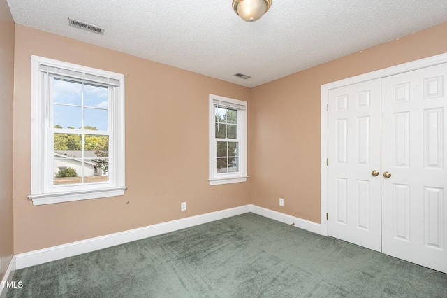 unfurnished bedroom featuring a closet, a textured ceiling, and carpet flooring