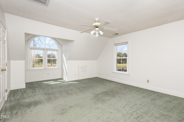 additional living space featuring a textured ceiling, ceiling fan, carpet floors, and lofted ceiling