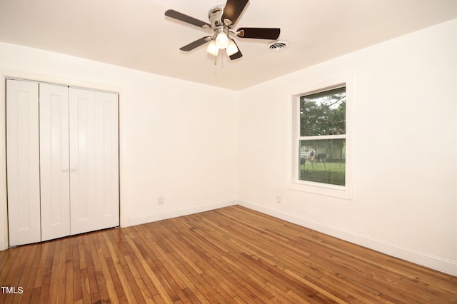 unfurnished bedroom with hardwood / wood-style floors, ceiling fan, and a closet