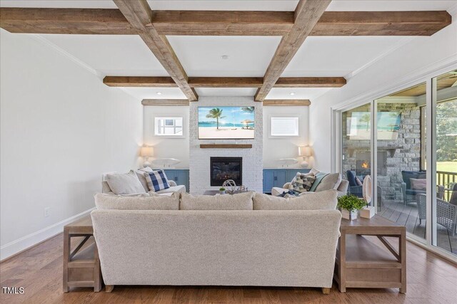 living room featuring a large fireplace, coffered ceiling, beamed ceiling, and hardwood / wood-style floors